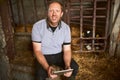 Its easy to run my dairy farm with this tablet. Cropped portrait of a male farmer using a tablet while sitting in a barn Royalty Free Stock Photo