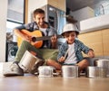 Its a father-son collaboration. Shot of a happy father accompanying his young son on the guitar while he drums on a set Royalty Free Stock Photo