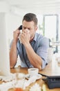 Its flu season. a young businessman blowing his nose while speaking on the phone in an office. Royalty Free Stock Photo