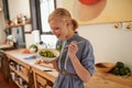 Its full of antioxidents. A young woman eating a bowl full of leafy greens in a rustic kitchen.