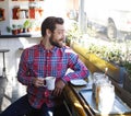Its a good day to have a good day. a young man holding a cup of coffee in a cafe. Royalty Free Stock Photo