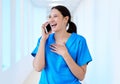 Its so good to hear your voice. a young dental assistant using her smartphone to make a call.
