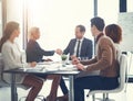 Its great to finally meet you. a two corporate colleagues shaking hands during a boardroom meeting.