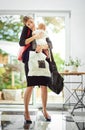 Its hard being a working mom. a busy businesswoman carrying a shopping bag and her baby while talking on the phone on Royalty Free Stock Photo