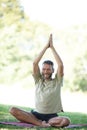 Its his time to unwind. Full length shot of a handsome mature man doing yoga outdoors. Royalty Free Stock Photo