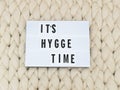 ITS HYGGE TIME word on lightbox on knit background. Cozy compozition. Knit background.