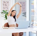 Its important to stretch your body during the day. Shot of a young businesswoman taking a stretch break at work.