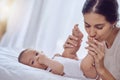 Its almost impossible to resist kissing those cute baby feet. a young woman bonding with her baby boy at home. Royalty Free Stock Photo