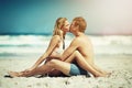 Its a matter of love. Full length shot of an affectionate young couple sitting face to face on the beach. Royalty Free Stock Photo