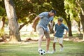 Its moments like these that will be remembered. an adorable little boy playing soccer with his father in the park. Royalty Free Stock Photo