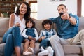 Its movie time. a couple watching something on the television with their two young kids. Royalty Free Stock Photo