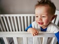 Its nap time when I say so. a cute little baby boy standing in his cot. Royalty Free Stock Photo