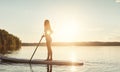 Its never too late to go paddling on a lake. an attractive young woman paddle boarding on a lake. Royalty Free Stock Photo