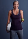 Its no secret that you need to eat healthy. Studio portrait of an attractive mature woman holding an apple and a Royalty Free Stock Photo
