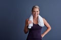 Its no sweat. Studio portrait of an attractive mature woman in sportswear standing with a towel around her neck against Royalty Free Stock Photo