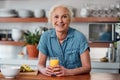 Its not breakfast without a vitamin C boost. a mature woman having orange juice with her breakfast in the kitchen at Royalty Free Stock Photo