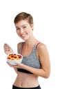 Its not about eating less, its about eating right. Studio portrait of a fit young woman eating a bowl of fruit and Royalty Free Stock Photo