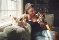 Its not a home with dogs. a young woman having coffee and relaxing with her dogs on the sofa at home.