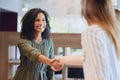 Its a pleasure to finally meet you. Low angle shot of two young businesswomen shaking hands during a meeting in the