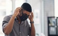 Its a precautionary measure we have to take. a young businessman putting on a face mask in an office.