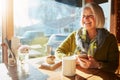 Its quite cosy in here. a senior woman texting on her cellphone in a cafe. Royalty Free Stock Photo