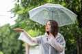 Its raining down hard. Shot of a young asian woman standing in the rain with an umbrella Royalty Free Stock Photo