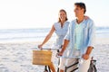 Its so refreshing to be outdoors. A mature couple enjoying a bike ride on the beach together. Royalty Free Stock Photo