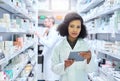 Its the smartest way to manage a modern pharmacy. Shot of a young woman using a digital tablet to do inventory in a Royalty Free Stock Photo