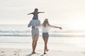 Its such a beautiful day to be on the beach. Rearview shot of an unrecognizable father carrying his daughter on his Royalty Free Stock Photo