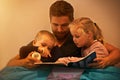 Its their favorite book...A father reading a bedtime story to his kids. Royalty Free Stock Photo