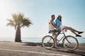 Its their version of romantic walks on the beach. a young couple riding a bicycle together on the promenade. Royalty Free Stock Photo