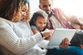Its time to learn about technology. an adorable little girl and her parents using a digital tablet together on the sofa Royalty Free Stock Photo