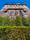 Eastern State Penitentiary tower in Philadelphia, USA, seen from below in perspective with green vegetation and clear blue sky