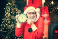 Its almost twelve clock. Santa Claus at home. Happy Christmas Santa with clock. Greeting Christmas card. Merry Christmas