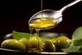 In its various forms, olive oil is poured gracefully into a spoon Royalty Free Stock Photo