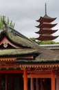 vermillion pagoda rises above mossy roof of shrine