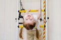 Ittle girl hangs on the stairs upside down Royalty Free Stock Photo