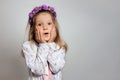 Ittle girl in white dress and purple wreath on gray isolated background Royalty Free Stock Photo