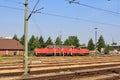 View of red locomotive and multiple train tracks from platform at Itzehoe train station in summer Royalty Free Stock Photo