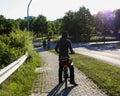 View from behind silhouette of man on bicycle ride on sidewalk