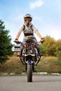 Vertical photo of young strong biker sitting on sport motorcycle.