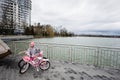 Ivano-Frankivsk, Ukraine - March, 2023: Girl with pink rose bycicle near lake