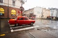 Ivano-Frankivsk, Ukraine - March, 2023: Red Moskvich AZLK Soviet classic retro car driving on rainy street