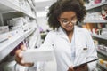 Ive been looking for this. a cheerful young female pharmacist checking stock on the shelves of a pharmacy. Royalty Free Stock Photo