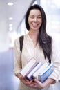 Ive a bit of studying to do....Portrait of a female college student carrying books in a hallway. Royalty Free Stock Photo