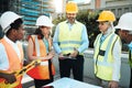 Ive got the clients plans right here. a diverse group of contractors standing outside together and having a discussion Royalty Free Stock Photo