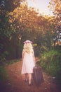 Ive got everything I need. a unrecognizable little girl walking with a suitcase on a dirt road outside in nature. Royalty Free Stock Photo