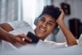 Ive got my quarantine entertainment covered. a young man using a smartphone and headphones while relaxing on his bed at Royalty Free Stock Photo