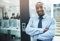 Ive got an open door policy. Portrait of a young businessman standing with her arms crossed in an office doorway. Royalty Free Stock Photo