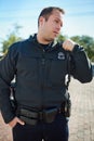 Ive got the situation under control. a handsome young policeman radioing in with headquarters. Royalty Free Stock Photo